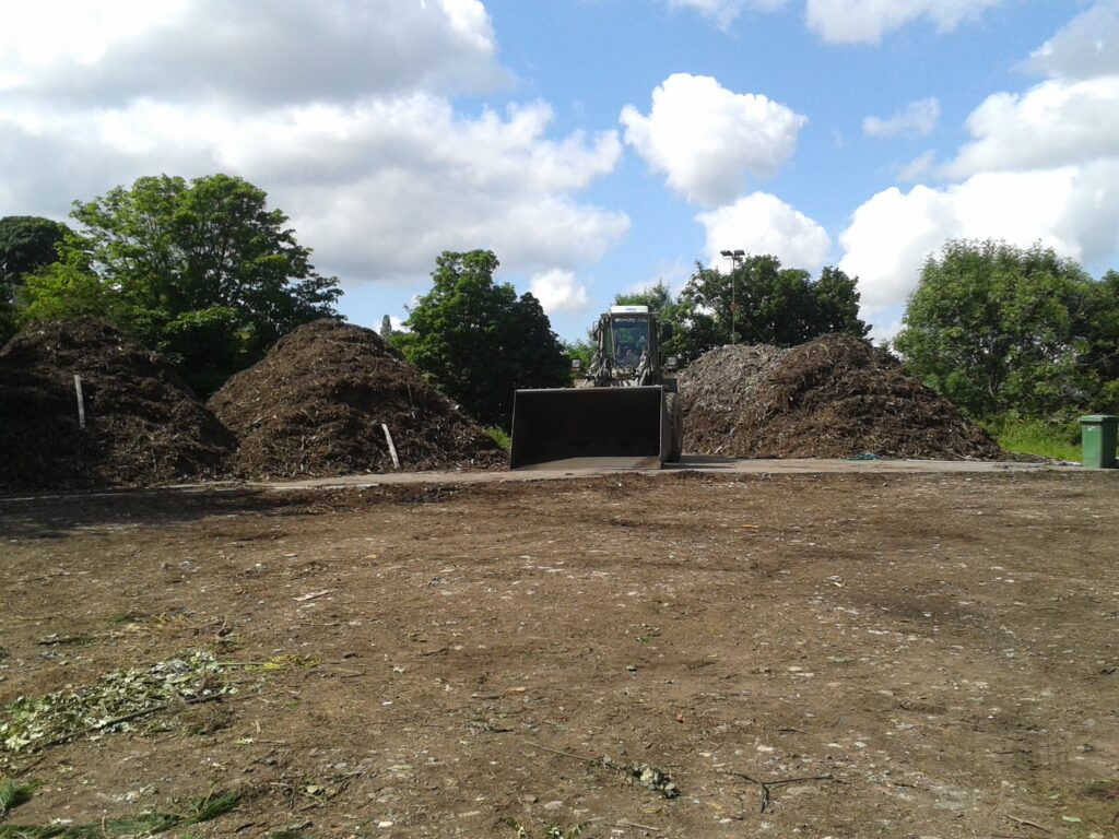 The Green Estate green waste which has been shredded and moved into windrows by a digger to produce compost